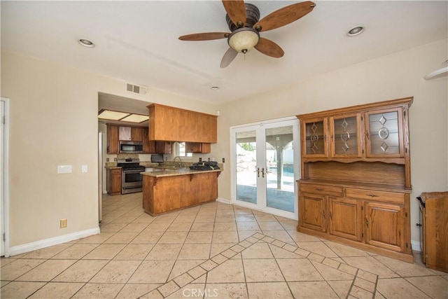 kitchen featuring visible vents, glass insert cabinets, a peninsula, stainless steel appliances, and french doors