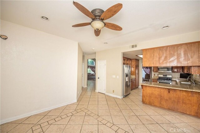 kitchen with light countertops, visible vents, appliances with stainless steel finishes, a sink, and a peninsula