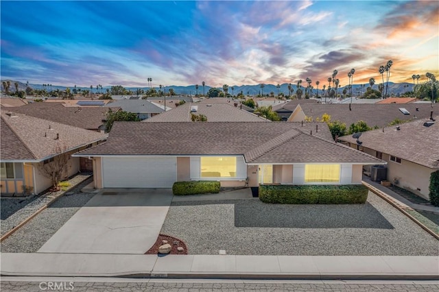 ranch-style home with a residential view, cooling unit, an attached garage, and stucco siding