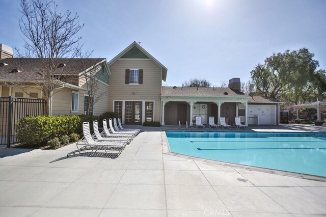 pool featuring fence and a patio