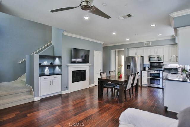264 Blue Sky Dr, Tustin, CA 92782 - interior space with dark countertops, a ceiling fan, crown molding, a glass covered fireplace, and appliances with stainless steel finishes