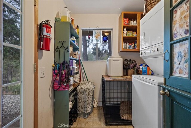 clothes washing area featuring stacked washer / dryer