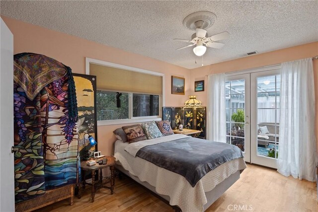 bedroom featuring a textured ceiling, visible vents, a ceiling fan, access to outside, and light wood finished floors