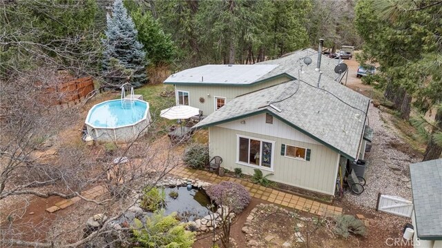 rear view of house featuring an outdoor pool, a patio, and fence