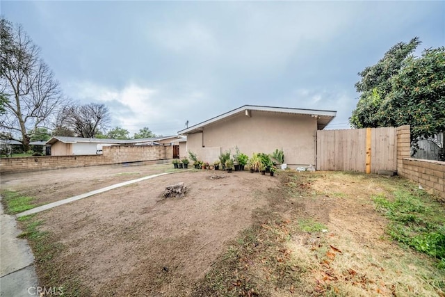 exterior space featuring fence and stucco siding