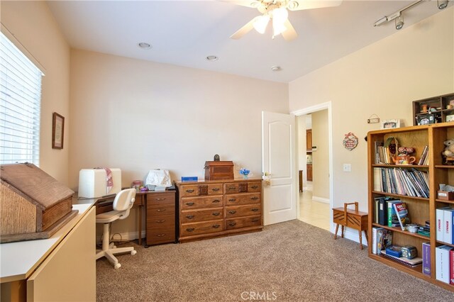 office space with rail lighting, a ceiling fan, and light colored carpet