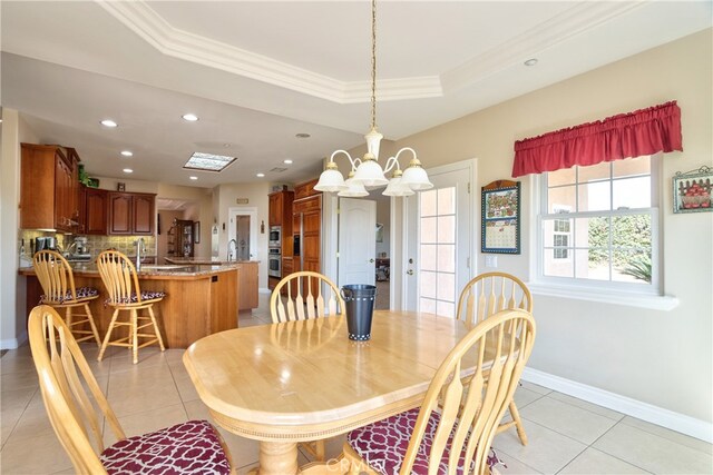 dining space featuring crown molding, a tray ceiling, recessed lighting, and baseboards