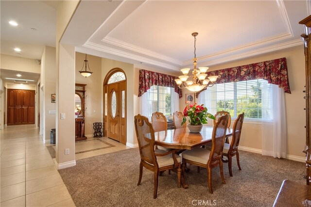 dining space featuring a raised ceiling, baseboards, an inviting chandelier, and light tile patterned floors