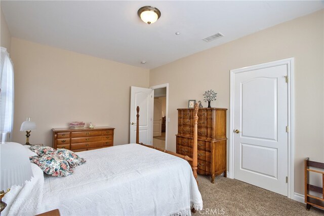 carpeted bedroom featuring visible vents