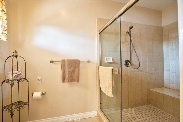 full bath with a stall shower and baseboards