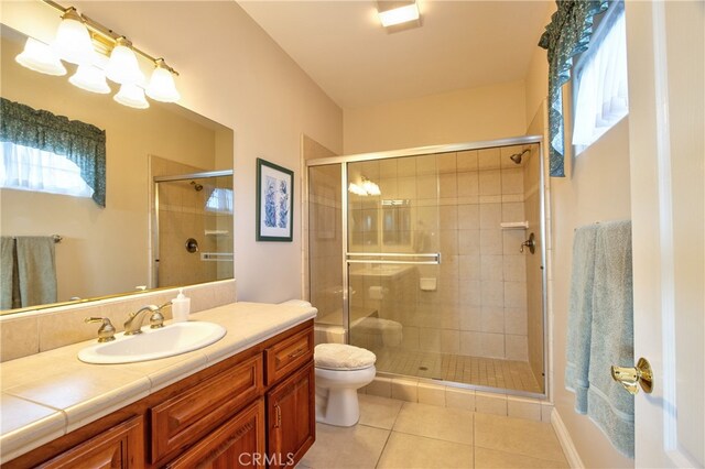 bathroom featuring a stall shower, tile patterned flooring, vanity, and toilet