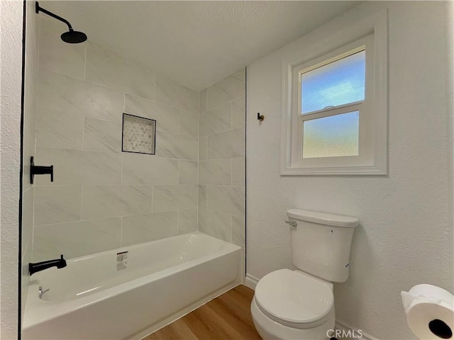 full bath with toilet, shower / tub combination, baseboards, and wood finished floors