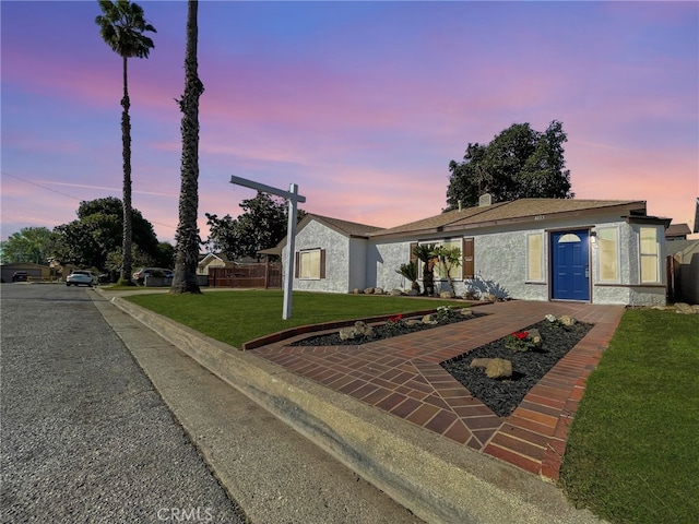 view of front of house featuring a lawn and stucco siding