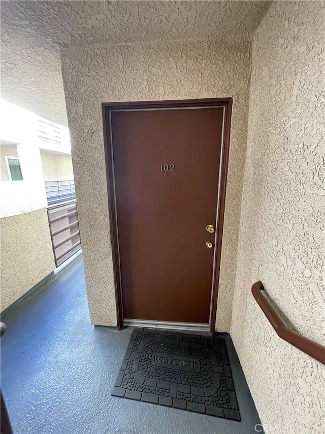 entrance to property with a balcony and stucco siding