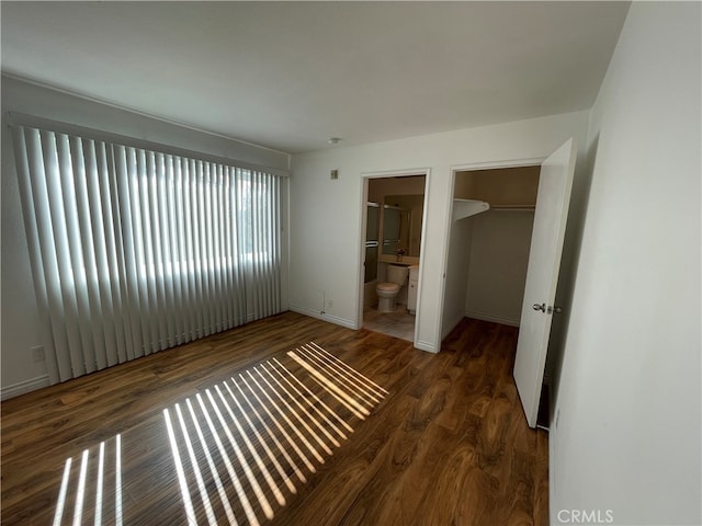 10115 Pinewood Ave Unit 102, Tujunga, CA 91042 - unfurnished bedroom featuring wood finished floors, a spacious closet, a closet, and ensuite bath