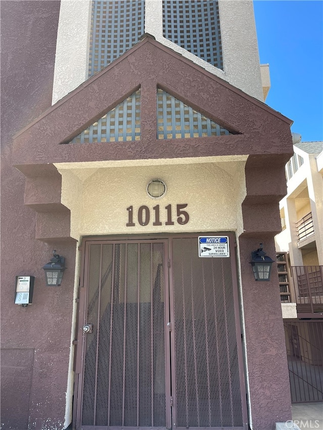 doorway to property featuring stucco siding