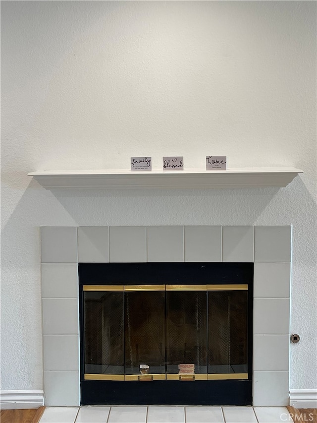 details featuring a textured wall and a tile fireplace