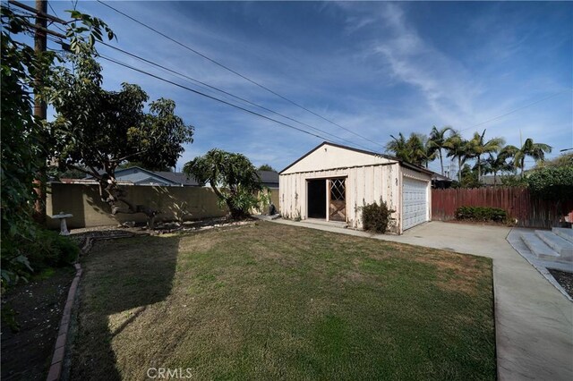 view of yard with an outbuilding, fence, and a detached garage