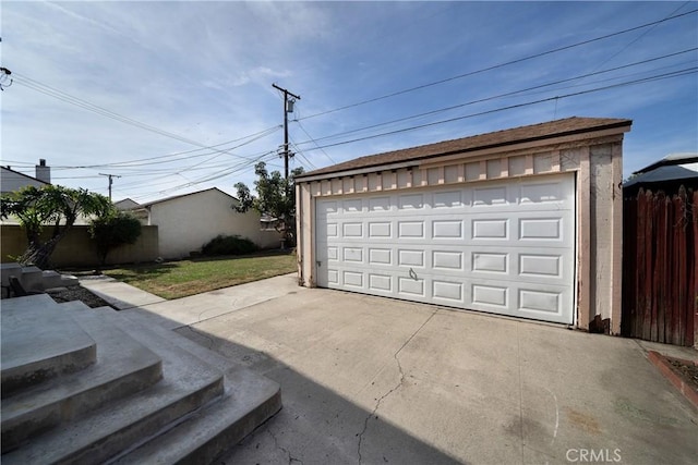 detached garage featuring fence