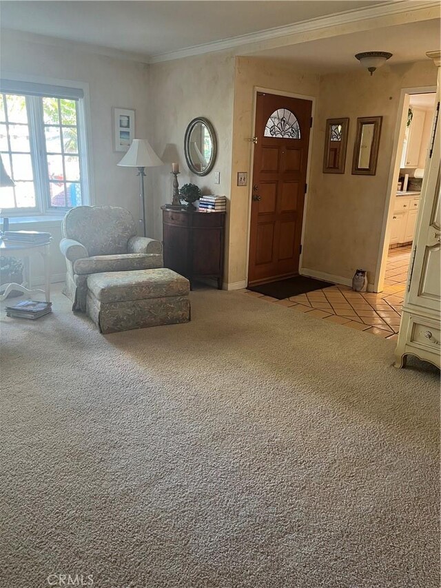 foyer entrance with light carpet, crown molding, and baseboards