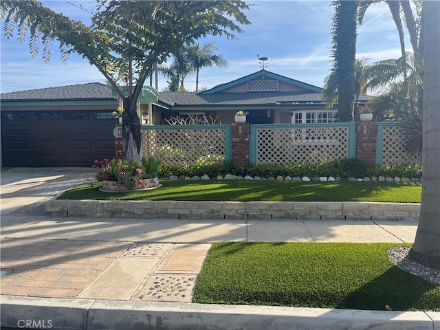 view of front of property featuring driveway, a front lawn, and an attached garage