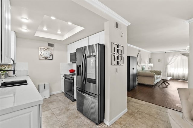 kitchen featuring black electric range, a raised ceiling, visible vents, open floor plan, and stainless steel fridge with ice dispenser