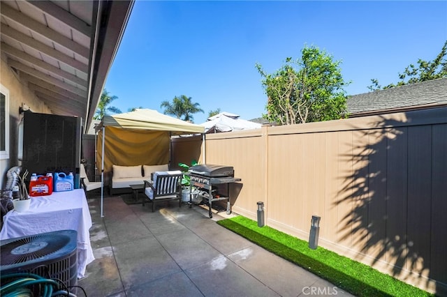 view of patio featuring a fenced backyard, an outdoor hangout area, and grilling area