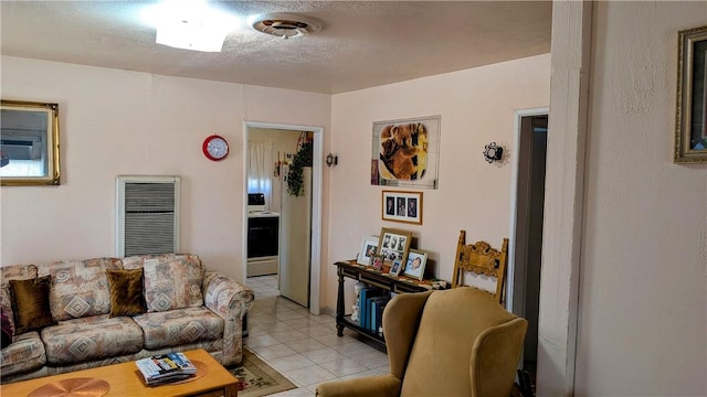 living area featuring visible vents, a textured ceiling, and light tile patterned floors