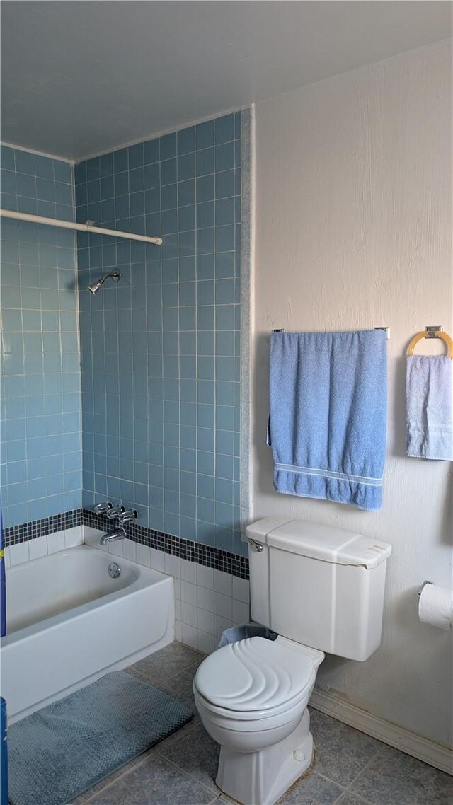 bathroom featuring  shower combination, tile patterned flooring, baseboards, and toilet