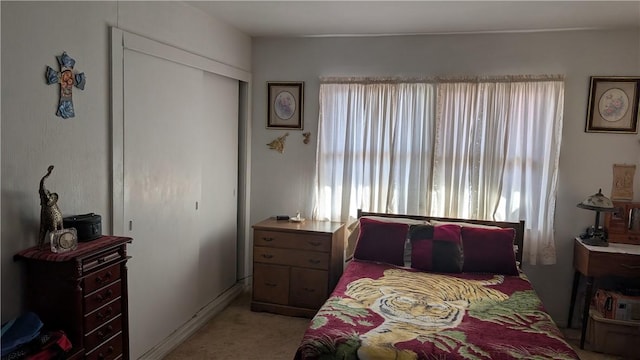 bedroom with a closet and light colored carpet