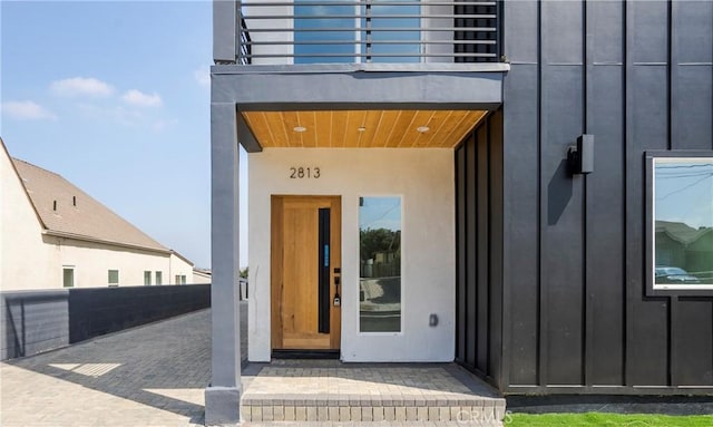 property entrance featuring board and batten siding and a balcony