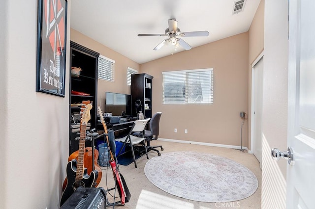 office space featuring carpet flooring, visible vents, baseboards, a ceiling fan, and vaulted ceiling