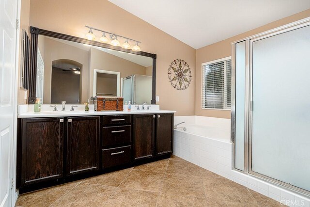 full bath featuring a stall shower, tile patterned floors, a sink, a garden tub, and double vanity