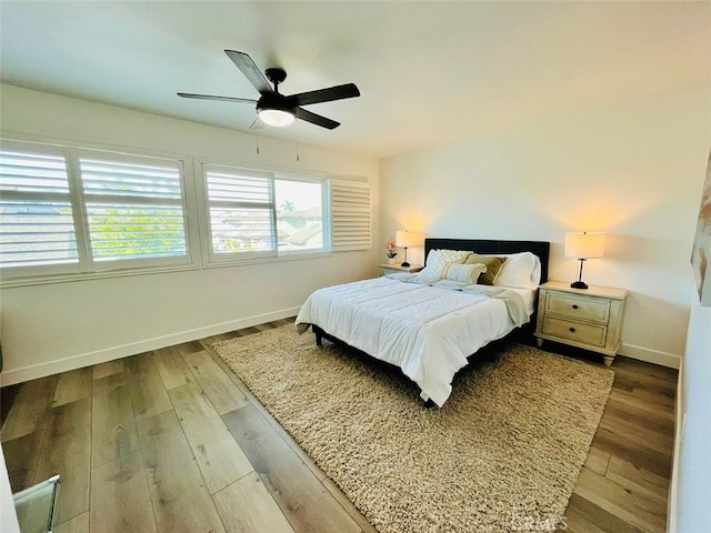 bedroom with baseboards, ceiling fan, and wood finished floors