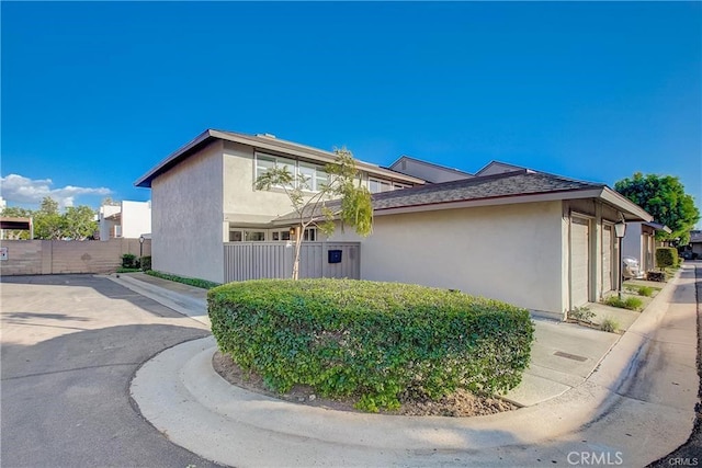 view of property exterior featuring fence and stucco siding
