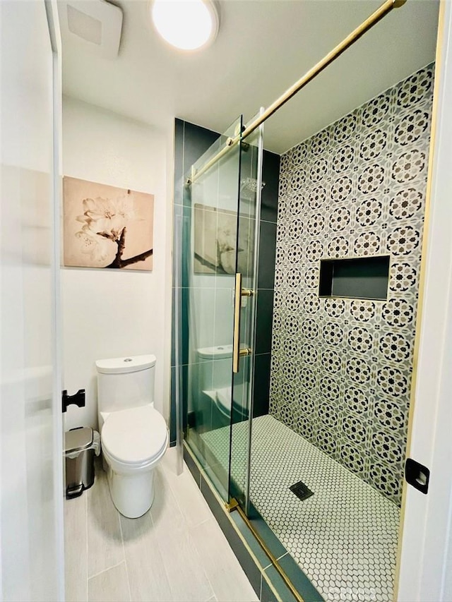 full bathroom featuring a shower stall and toilet