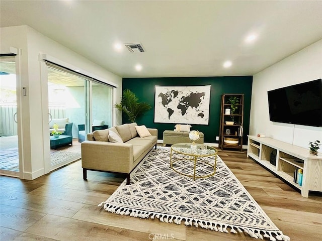 living room featuring visible vents, wood-type flooring, and recessed lighting