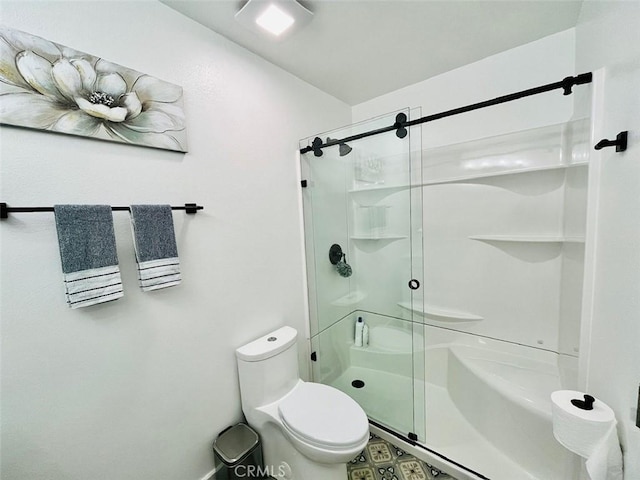 bathroom featuring a stall shower and toilet