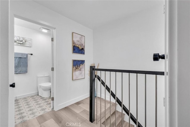 14142 Via Posada Unit 29, Tustin, CA 92780 - corridor featuring an upstairs landing, baseboards, and wood finished floors