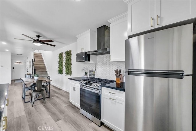 14142 Via Posada Unit 29, Tustin, CA 92780 - kitchen with appliances with stainless steel finishes, wall chimney exhaust hood, ceiling fan, tasteful backsplash, and dark countertops