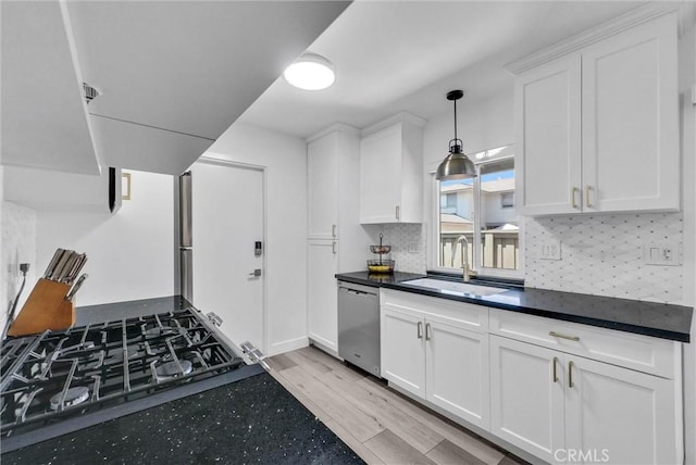14142 Via Posada Unit 29, Tustin, CA 92780 - kitchen featuring dishwasher, a sink, dark countertops, and white cabinetry