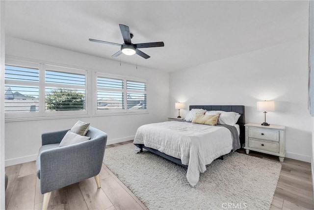 14142 Via Posada Unit 29, Tustin, CA 92780 - bedroom with baseboards, light wood-style floors, and a ceiling fan