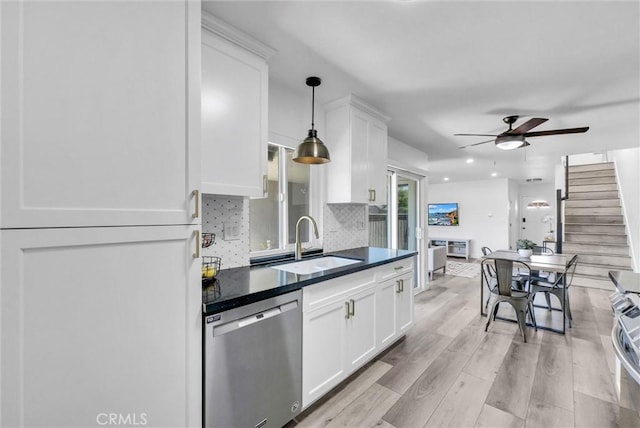 14142 Via Posada Unit 29, Tustin, CA 92780 - kitchen featuring appliances with stainless steel finishes, a sink, dark countertops, a ceiling fan, and white cabinetry