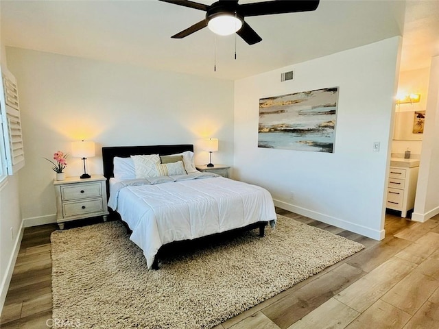 14142 Via Posada Unit 29, Tustin, CA 92780 - bedroom with wood finished floors, baseboards, ceiling fan, and ensuite bath