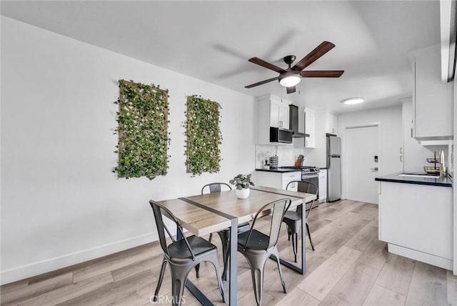 14142 Via Posada Unit 29, Tustin, CA 92780 - dining room with a ceiling fan, light wood-type flooring, and baseboards