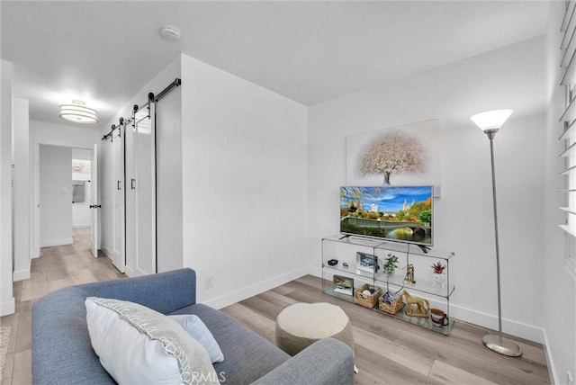 14142 Via Posada Unit 29, Tustin, CA 92780 - living area featuring a barn door, wood finished floors, and baseboards