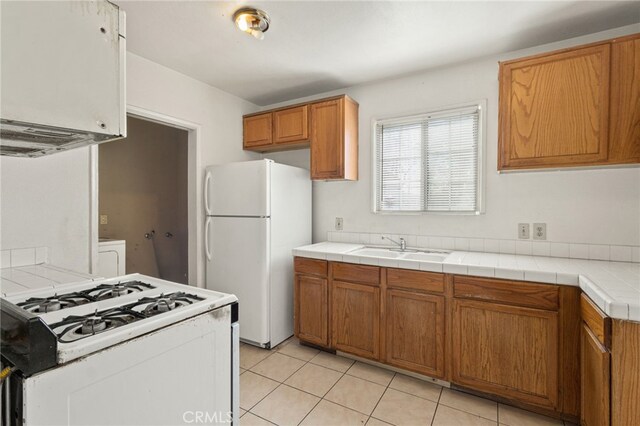 847 W 25th St, San Bernardino, CA 92405 - kitchen with white appliances, a sink, tile counters, and brown cabinets