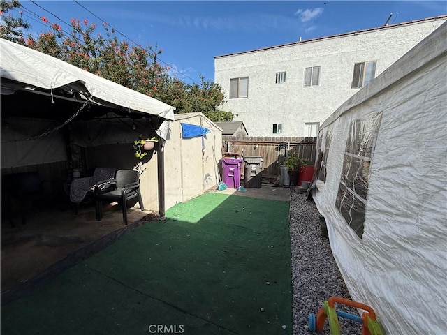 view of yard featuring a shed, an outdoor structure, and a fenced backyard