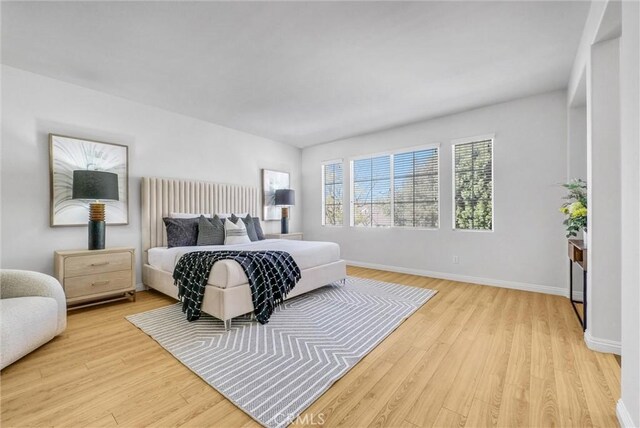 bedroom featuring light wood-type flooring and baseboards