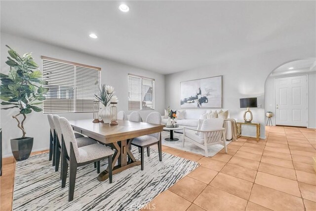 dining room with recessed lighting, arched walkways, and light tile patterned flooring